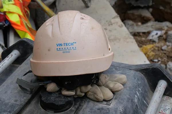 White hard hat resting on a pair of work gloves