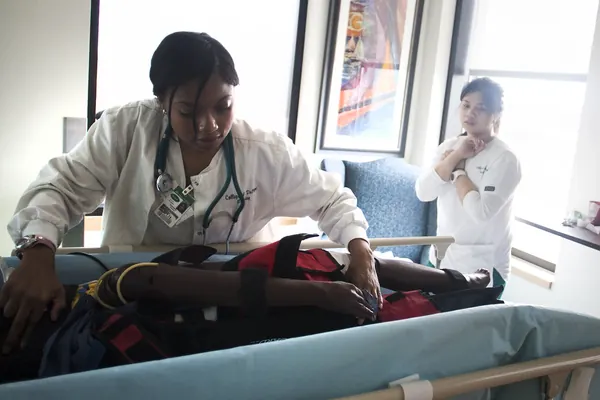 Nursing and EMT simulation exercise with a child-size patient simulator on a hospital bed