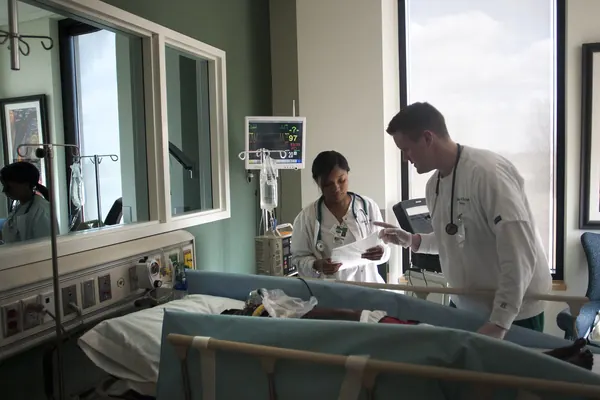 Nursing simulation room with a patient simulator in a hospital bed, a vital-signs monitor and IV pole