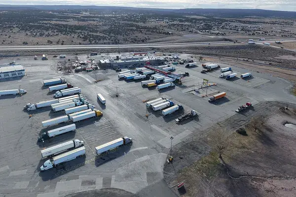 Rows of tractor-trailers parked at a truck stop along Interstate 40, seen from above