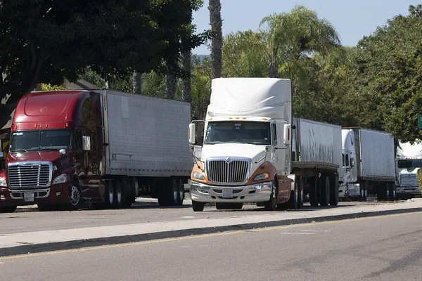 Tractor-trailers parked in a line along a street