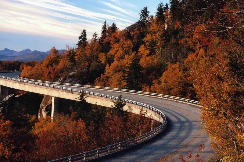 Blue Ridge Parkway curving along the Linn Cove Viaduct through autumn forest in North Carolina